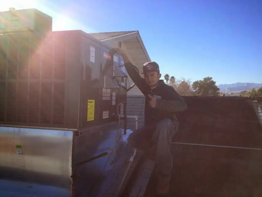 HVAC technician performing Heat Pump Repair on a rooftop unit in Moody